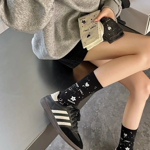 Detail showing mid-calf cotton socks with star patterns and street style lettering