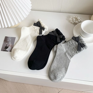 Detailed set of three cotton socks featuring ruffled edges and polka dot bow accents