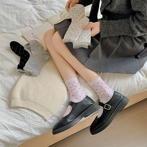 Close-up of sweet lace trim socks with polka dots paired with black leather shoes