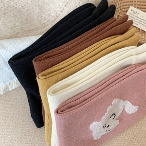 Détail de chaussettes en coton rose avec broderie animale blanche et maille douce