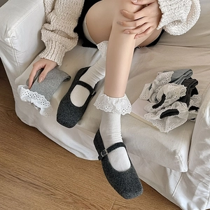 Close-up of Lolita style white knit socks with intricate lace trim and Mary Jane shoes