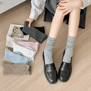 Vue détaillée de chaussettes en maille côtelée de diverses couleurs sur bois naturel