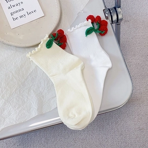 Détails des chaussettes blanches avec cerises crochetées et bords à volants doux