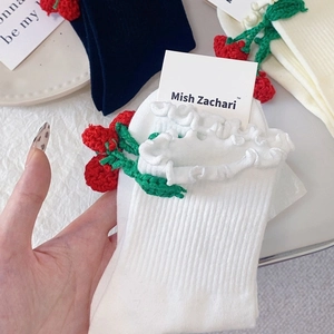 Détail d'une chaussette en coton blanc avec crochet cerise rouge et bordure à volants