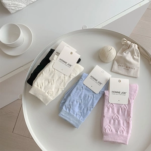 Detail of four pairs of ribbed socks with 3D embossed heart patterns in assorted colors