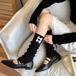 Détails des jambières en tricot noir avec nœuds en satin rose et chaussures Mary Jane