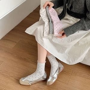Close-up of sweet lace-trimmed socks with polka dot patterns and feminine ruffle cuffs