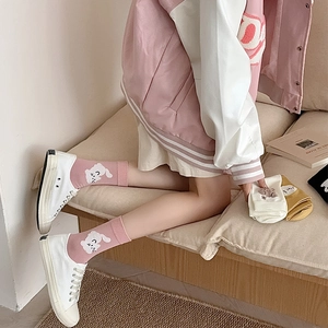 Gros plan sur la broderie lapin mignon et le motif ours à pois sur des chaussettes douces