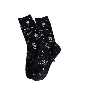 Black mid-calf knit socks with silver paint splatters, star patterns, and smile faces