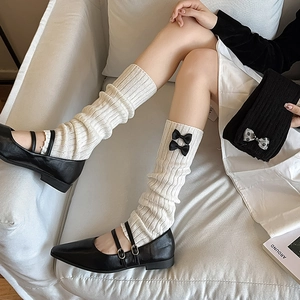 Texture de maille détaillée des jambières blanches avec nœuds noirs pour style hiver