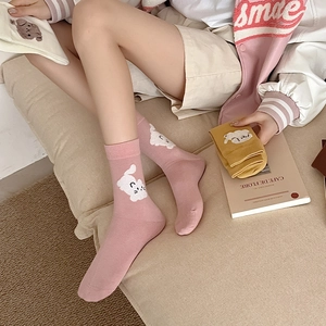 Gros plan sur des chaussettes en coton rose et jaune avec motifs de chats mignons