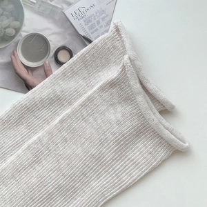 Gros plan de chaussettes en maille côtelée crème avec bord roulé et texture douce