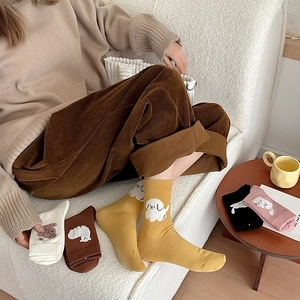 Détail de chaussettes mignonnes avec motifs de caniche et d'ours sur tissu douillet