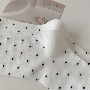 Close-up of white polka dot cotton socks with ribbed texture and chic Japanese style
