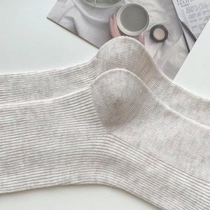 Gros plan sur la maille côtelée épaisse des chaussettes mi-mollet beige avoine