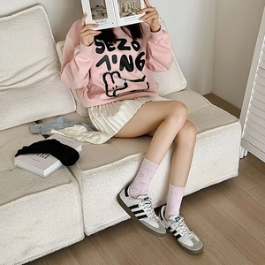 Detail of pink crewneck sweatshirt with rabbit graphic and heart pattern mid-calf socks