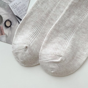 Gros plan détaillé de chaussettes en maille côtelée avoine montrant la texture du coton