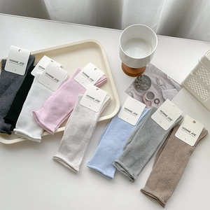 Gros plan de chaussettes en tricot côtelé à bords roulés en plusieurs couleurs avec étiquettes