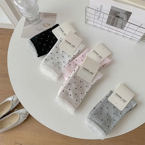 Detail of sweet polka dot mid-tube socks set with delicate lace trim in various colors