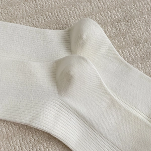 Close-up of white ribbed knit cotton calf socks showing high-quality fabric texture
