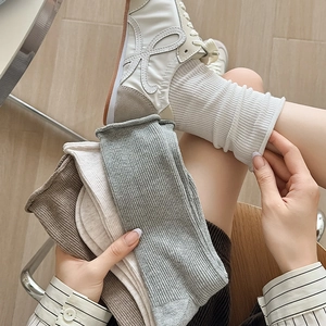 Détails des chaussettes en maille côtelée avec bord roulé en tons terreux