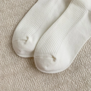 Close-up of white ribbed knit socks showing the soft cotton texture and reinforced toe