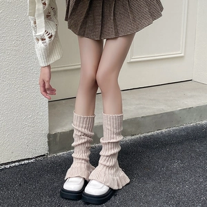 Beige knitted leg warmers with ruffle trim and ballet-style ribbed texture for winter fashion