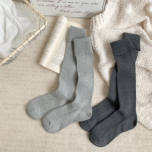 Detailed knit texture of light and dark grey ribbed calf socks for winter warmth