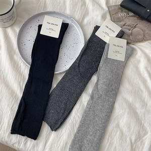Detail of three pairs of ribbed cotton socks in black, dark gray and light gray colors