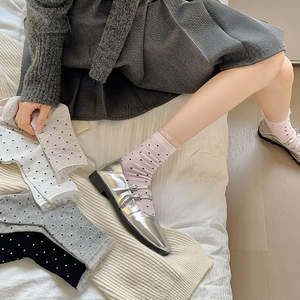 Detail of sweet polka dot socks with lace trim paired with silver Mary Jane shoes
