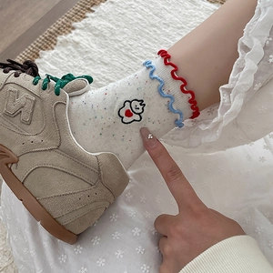 Close-up of Japanese style dotted socks with blue and red wavy edges and cute embroidery