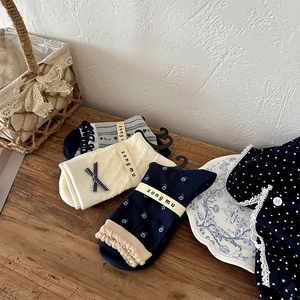Detailed flat lay of vintage floral mid-calf socks with bows and lace trimmings