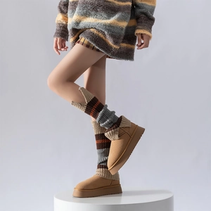 Close-up of retro striped knit leg warmers paired with platform chestnut suede boots