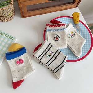 Close-up of assorted cotton socks featuring cartoon bear embroidery and ruffled edges