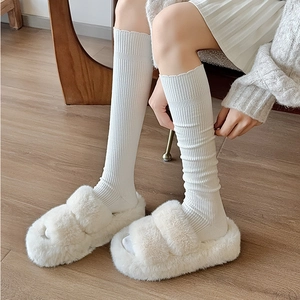 Cozy cream faux fur platform slippers paired with white ribbed knit knee-high socks