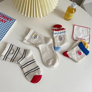 Close-up of Japanese style cotton socks featuring cute cartoon embroidery and stripe details