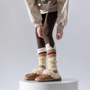 Detail of winter leg warmers with striped knit pattern and cozy button styling