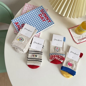 Flat lay of embroidered cotton socks with stripe patterns and wavy lettuce edge details