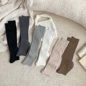 Detailed knit texture of six assorted solid color thigh-high ribbed stockings for women