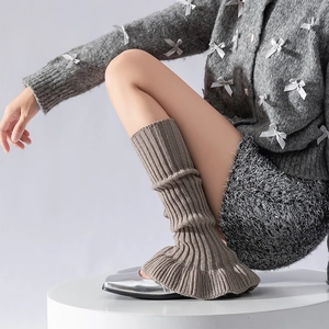Detail of coffee brown ribbed knit leg warmers styled with silver shoes for a balletcore look