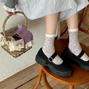 Close-up of lavender floral socks with lace trim and bow detail in retro style
