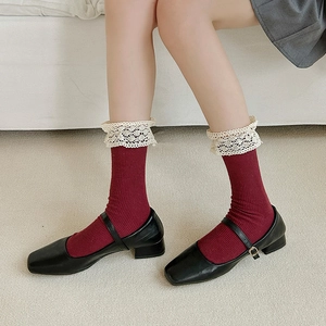 Detail of burgundy ribbed socks featuring delicate white lace trim and knit texture