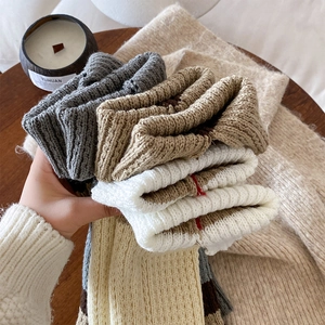 Close-up of ribbed knit leg warmers in various neutral colors for autumn winter style