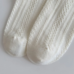 Vue macro détaillée de chaussettes en maille blanche avec texture torsadée fine