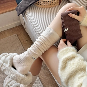Detail of ribbed wool calf socks with chic brand label and cozy knitted texture