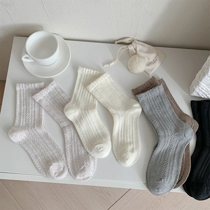 Vue détaillée de chaussettes en tricot à rayures verticales dans des tons neutres doux