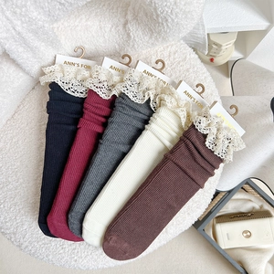 Detail of five-color vintage lace trim ribbed socks arranged on white fleece texture