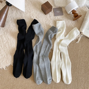 Detailed texture of cotton ribbed knit crew socks in black, grey and cream colors