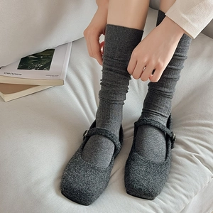 Detail of dark grey wool Mary Jane shoes paired with casual knitted crew socks