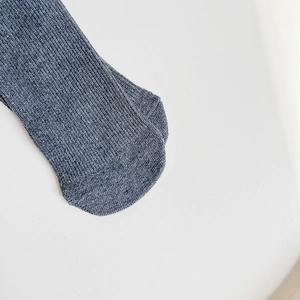 Macro detail of dark blue ribbed knit fabric on vintage lace socks for women